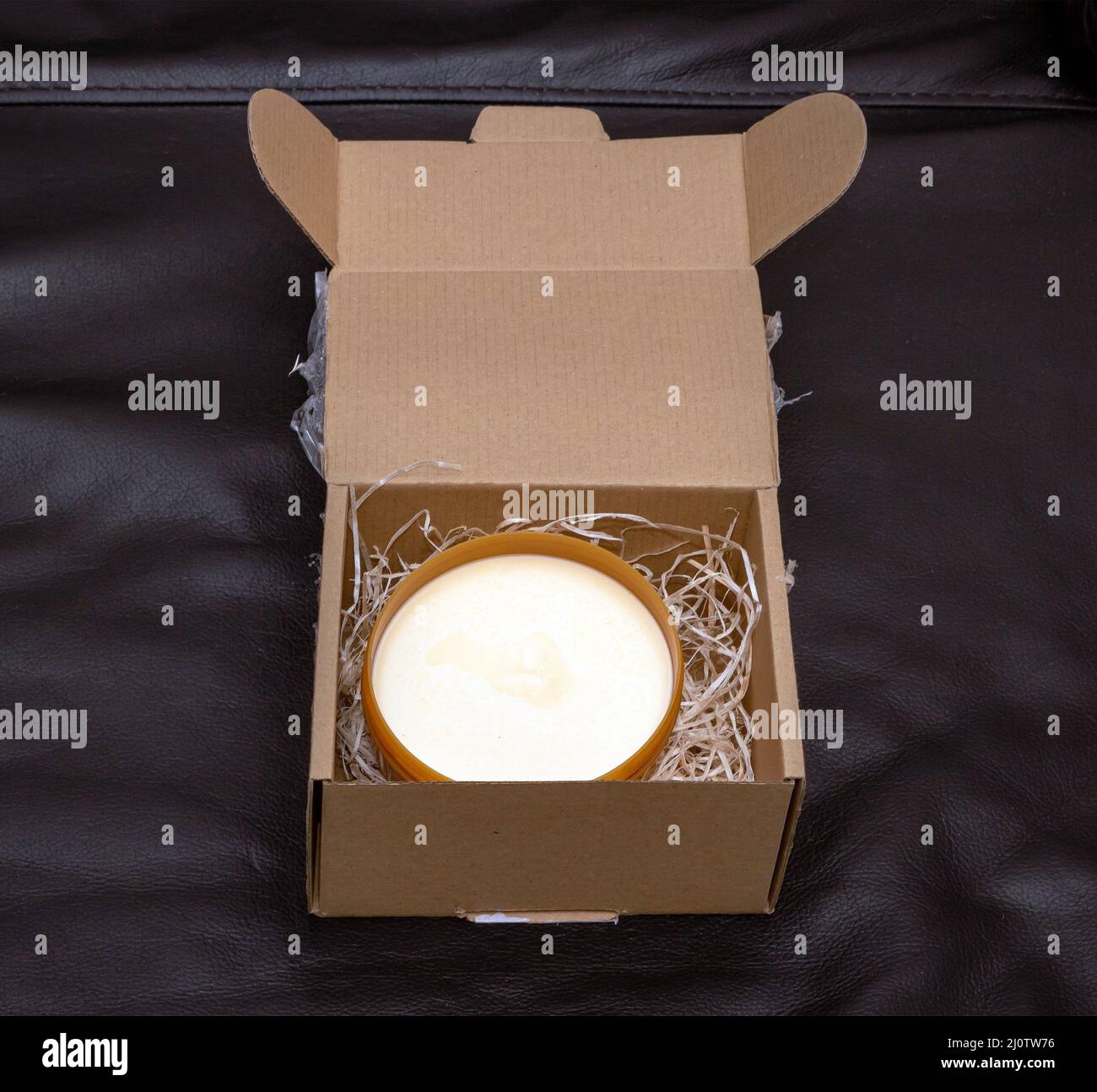 Open body cream inside cardboard package box Stock Photo