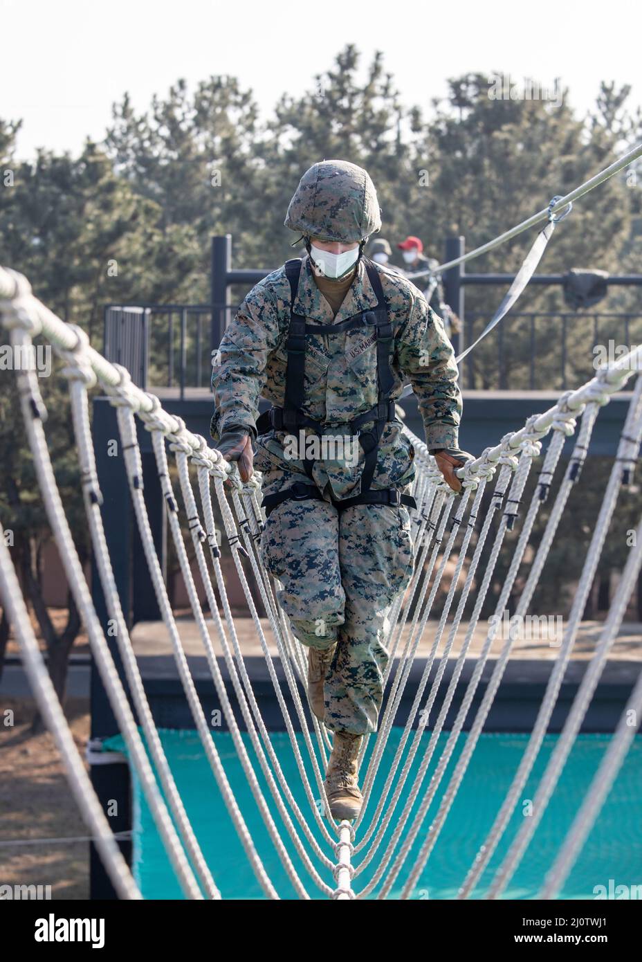 U.S. Marine Corps Lance Cpl. Parker Wicks, a Marine Air Ground Taskforce planner with U.S. Marine Corps Forces Korea, crosses a rope bridge during a ropes course with 3D Sustainment Group (Experimental), 3D Marine Logistics Group and Republic of Korea Marine Corps Ranger School in Pohang, South Korea, Jan. 27, 2022. The course increased the Marines’ readiness with rappelling and rope work while improving interoperability with our partners and allies. (U.S. Marine Corps photo by Sgt. Ash McLaughlin) Stock Photo
