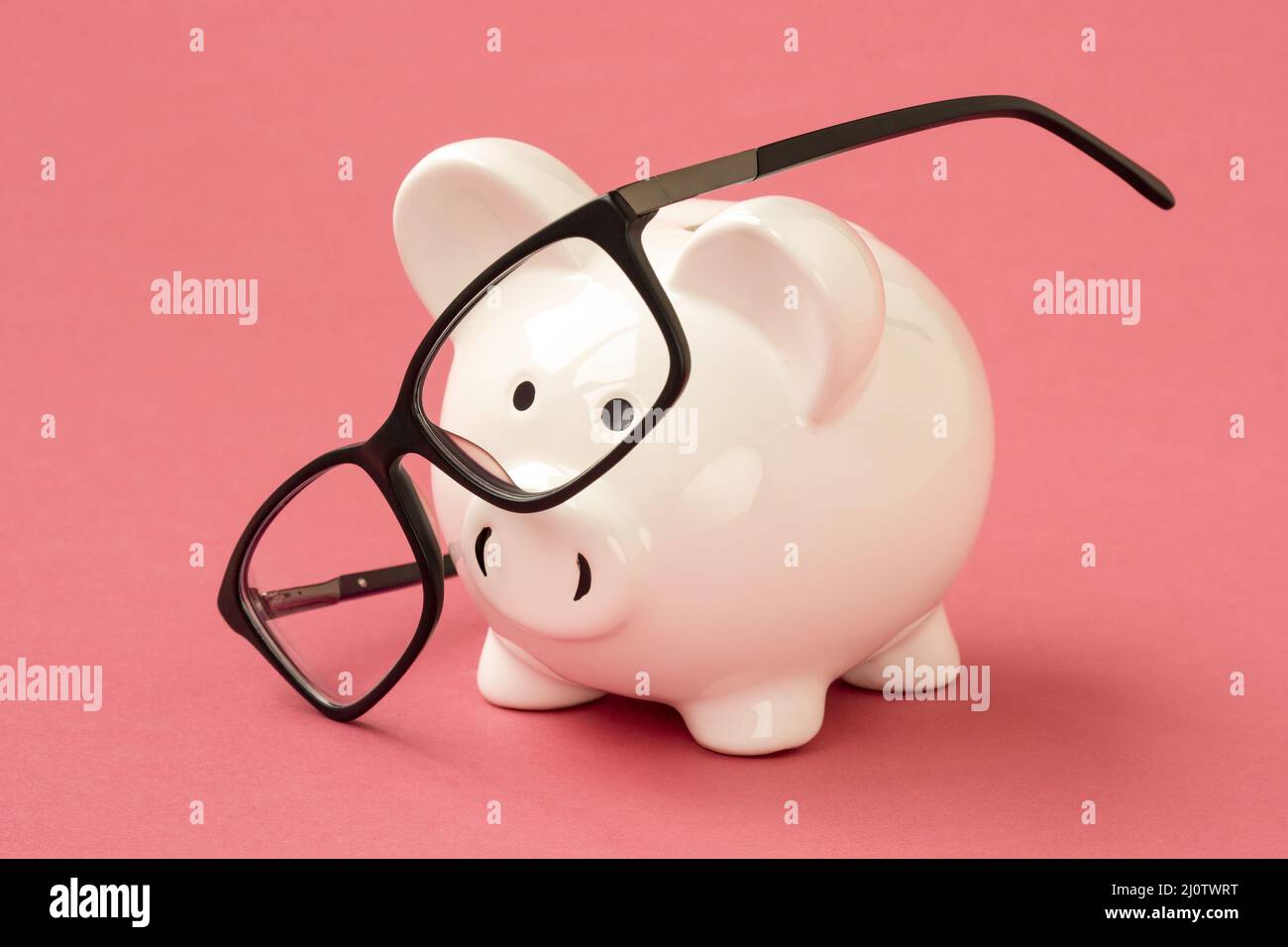 Piggy bank and eyeglasses on the pink background Stock Photo - Alamy