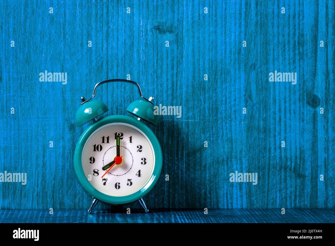 Old fashioned alarm clock on the blue wooden shelf Stock Photo - Alamy