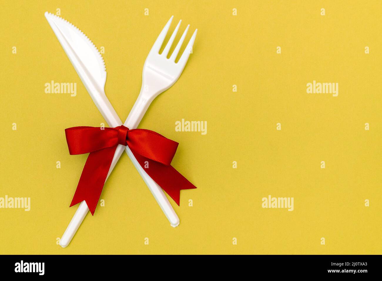 Disposable fork and knife decorated with red bow Stock Photo
