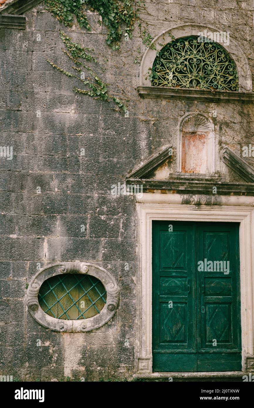 Facade of a stone house in Perast, darkened by time. Montenegro Stock Photo