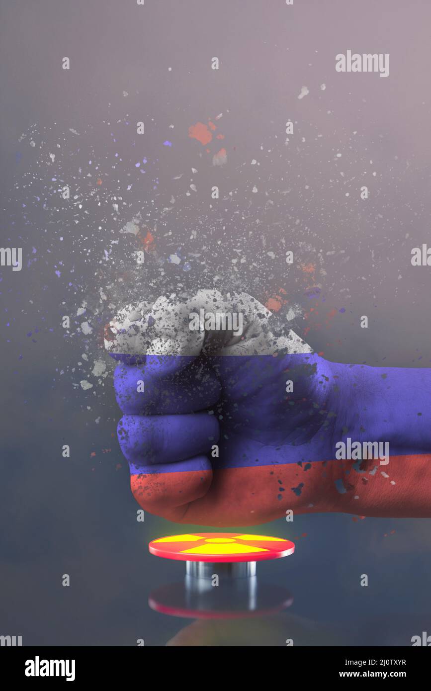 The threat of nuclear war. Russia threatens the world with nuclear weapons. A fist painted in the colors of the Russian flag presses a large red Stock Photo