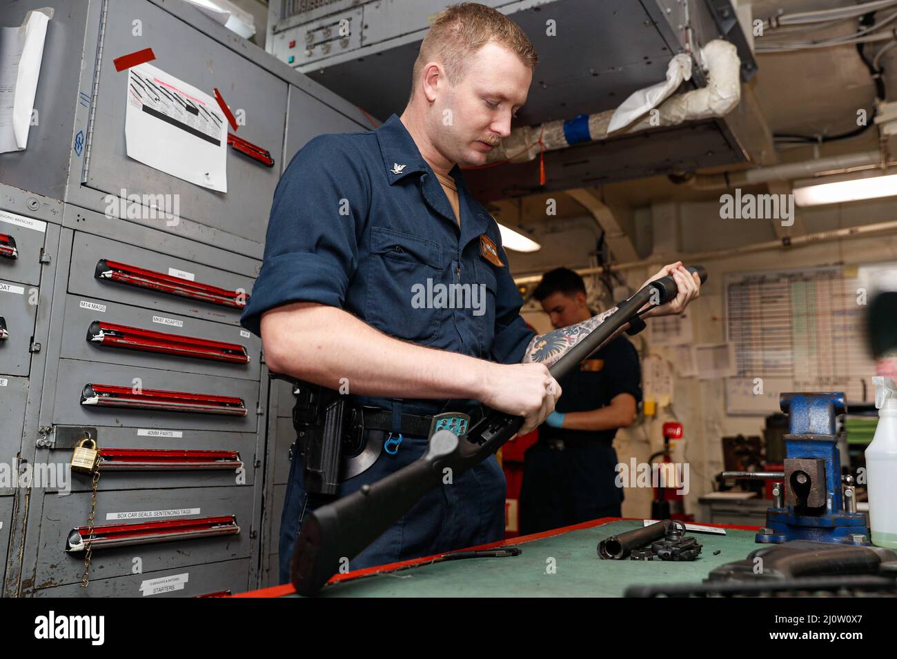 SOUTH CHINA SEA (Jan. 28, 2022) Gunner’s Mate 3rd Class Taylor Green, from Sheperd, Mont., disassembles and reassembles an M500 shotgun in the armory aboard the Nimitz-class aircraft carrier USS Abraham Lincoln (CVN 72). Abraham Lincoln Strike Group is on a scheduled deployment in the U.S. 7th Fleet area of operations to enhance interoperability through alliances and partnerships while serving as a ready-response force in support of a free and open Indo-Pacific region. (U.S. Navy photo by Mass Communication Specialist Seaman Apprentice Jett Morgan) Stock Photo