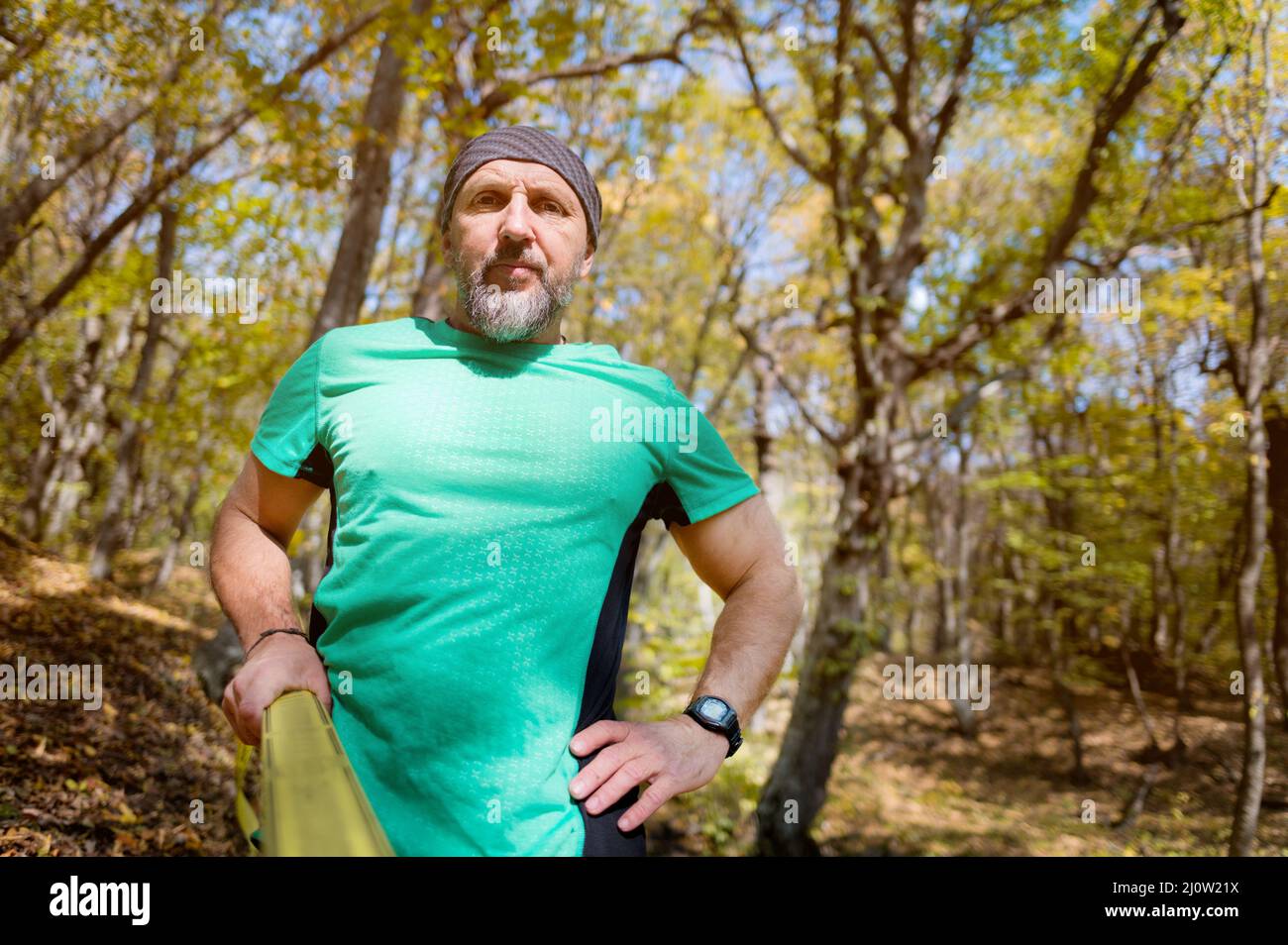 Portrait of a mature sports man with a beard next to a stretched slackline in the autumn forest in the afternoon. the concept of Stock Photo