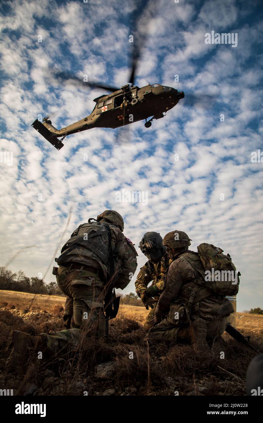 A flight paramedic and two Soldiers competing in the Jack L. Clark Jr.,  Army Best Medic Competition at Fort Hood, Texas prepare a simulated  casualty to be hoisted into a HH-60 Blackhawk