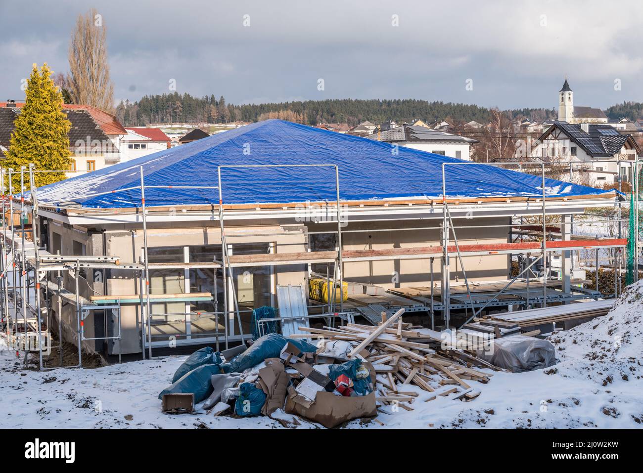 Shell construction of a bungalow with tarpaulin on the roof - building a house Stock Photo