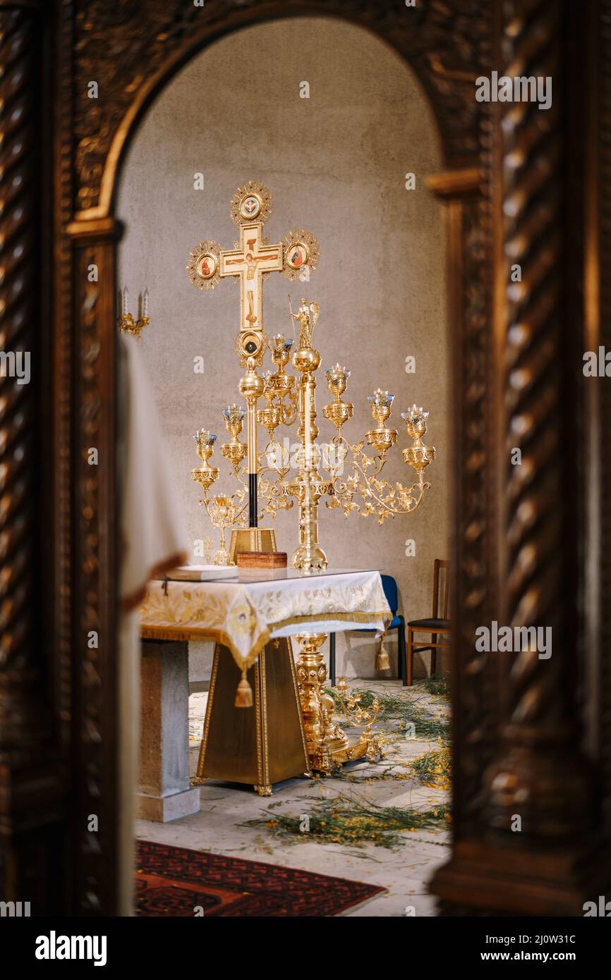 Branched gold candlestick on a table in front of a cross in the Church of St. Sava in Tivat. Montenegro Stock Photo