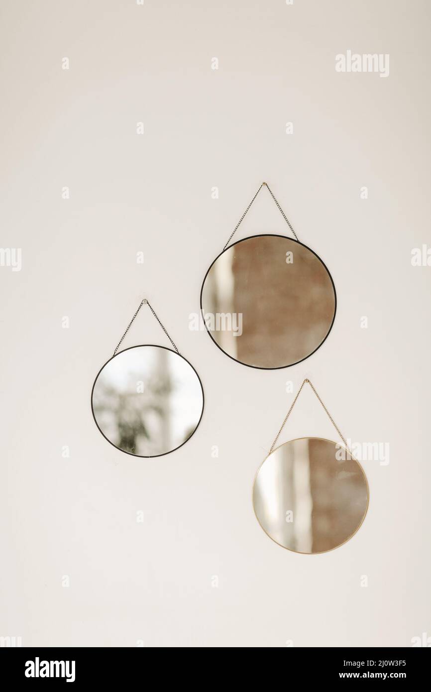 Close up photo of three round mirrors of different sizes hanging on
