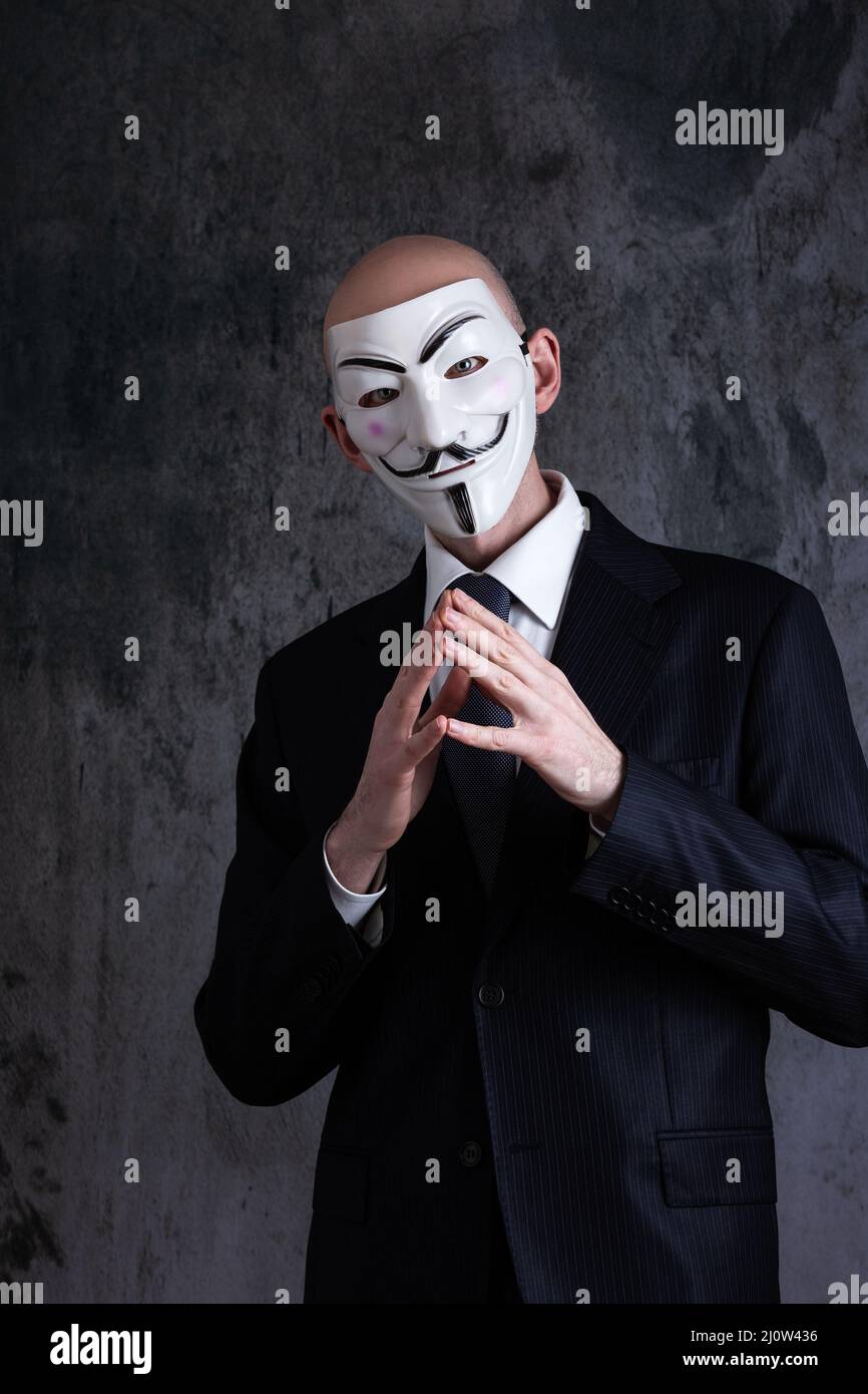 Midsection of a businessman wearing the mask of anonymous / Guy Fawkes Stock Photo