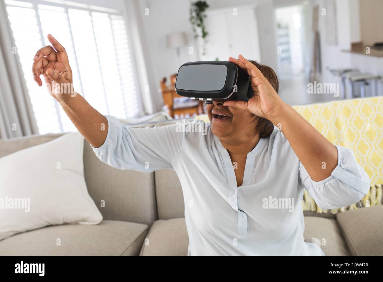 Happy african american senior woman pointing while wearing virtual ...