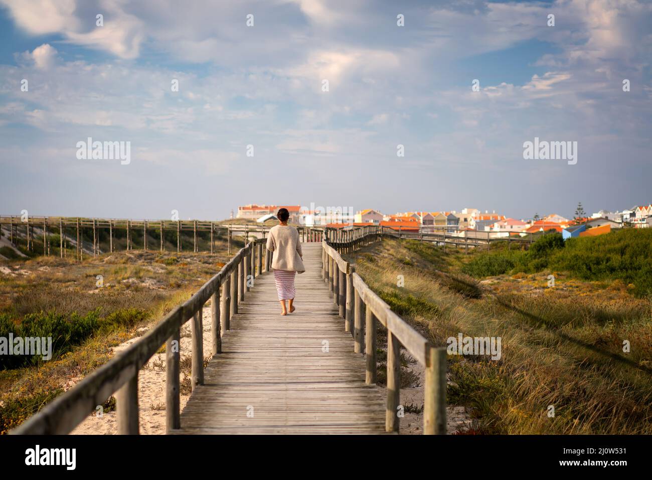 Woman walking on a pathway in Costa Nova near the beach in Aveiro, Portugal Stock Photo