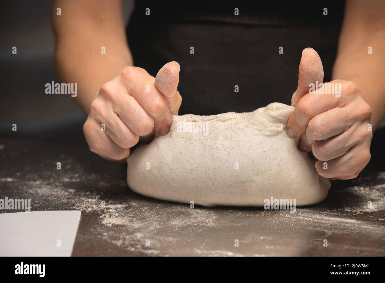Close-up baker making bread, female hands, kneading dough, cooking Stock Photo