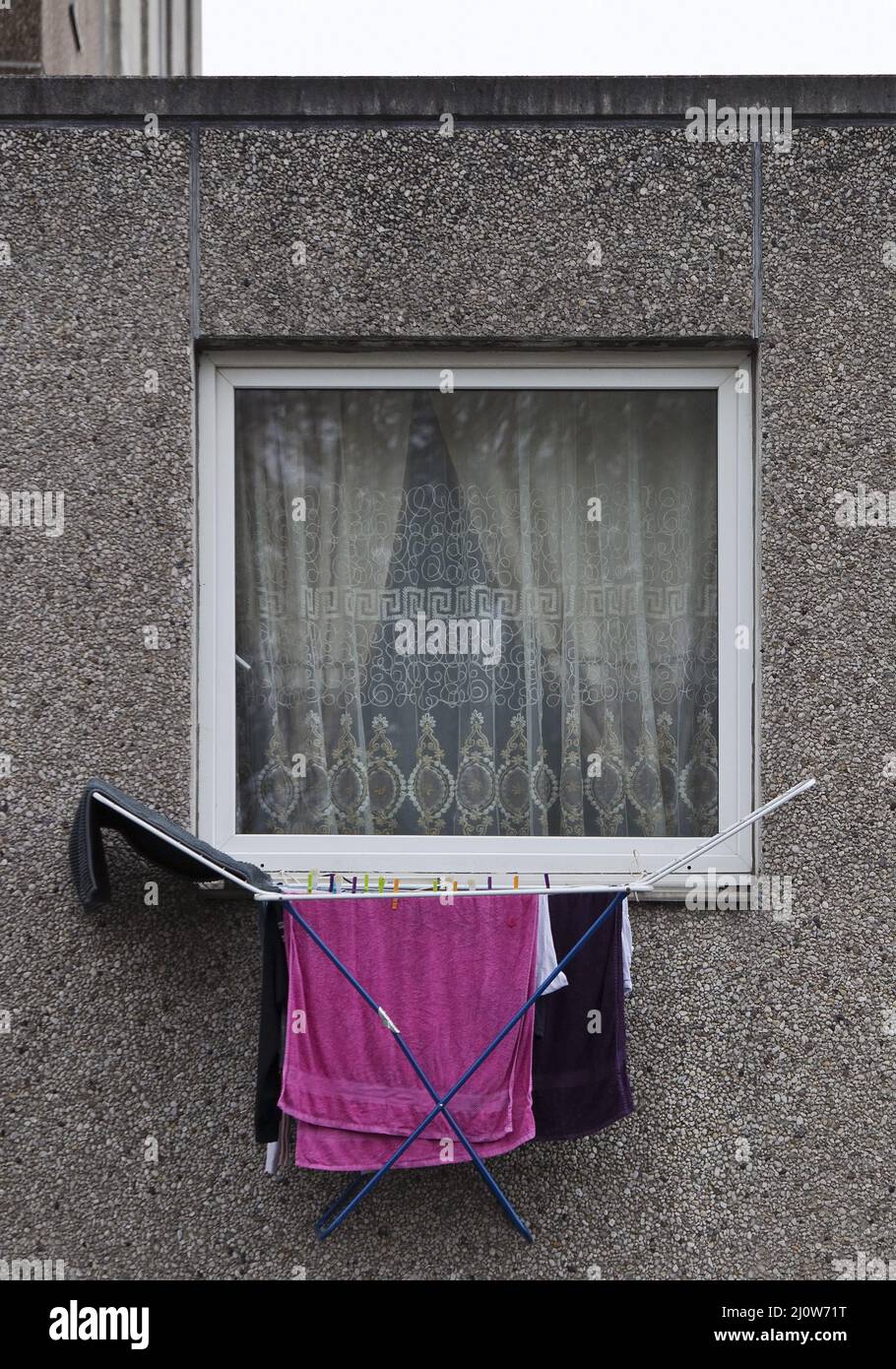 Laundry clothes hang out of the window on the first floor of a dreary apartment block, Goettingen Stock Photo