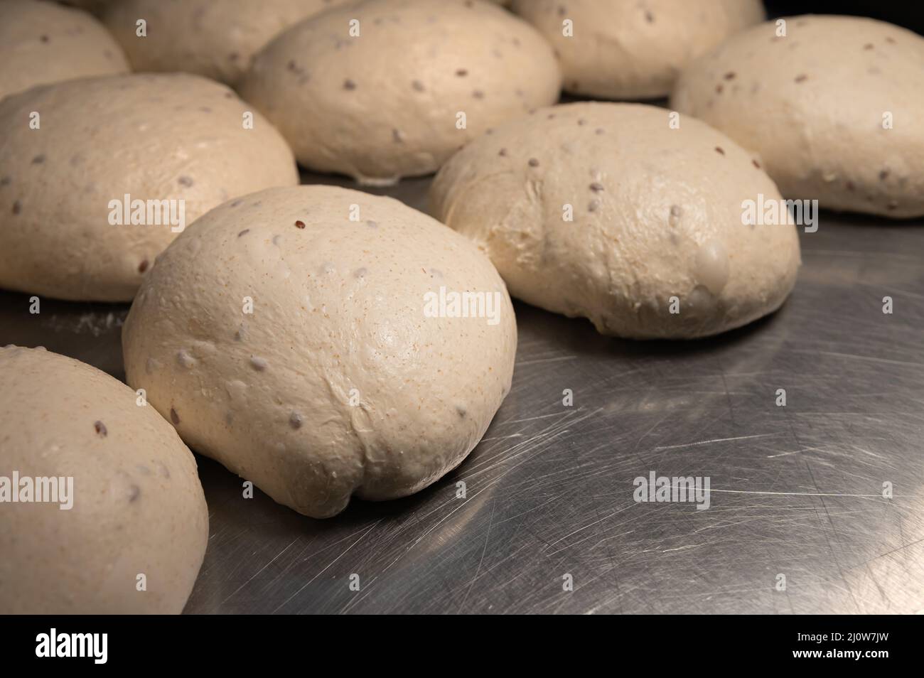 Close-up Homemade yeast dough buns for cutlets on a baking sheet. Hamburger buns dough pieces Stock Photo