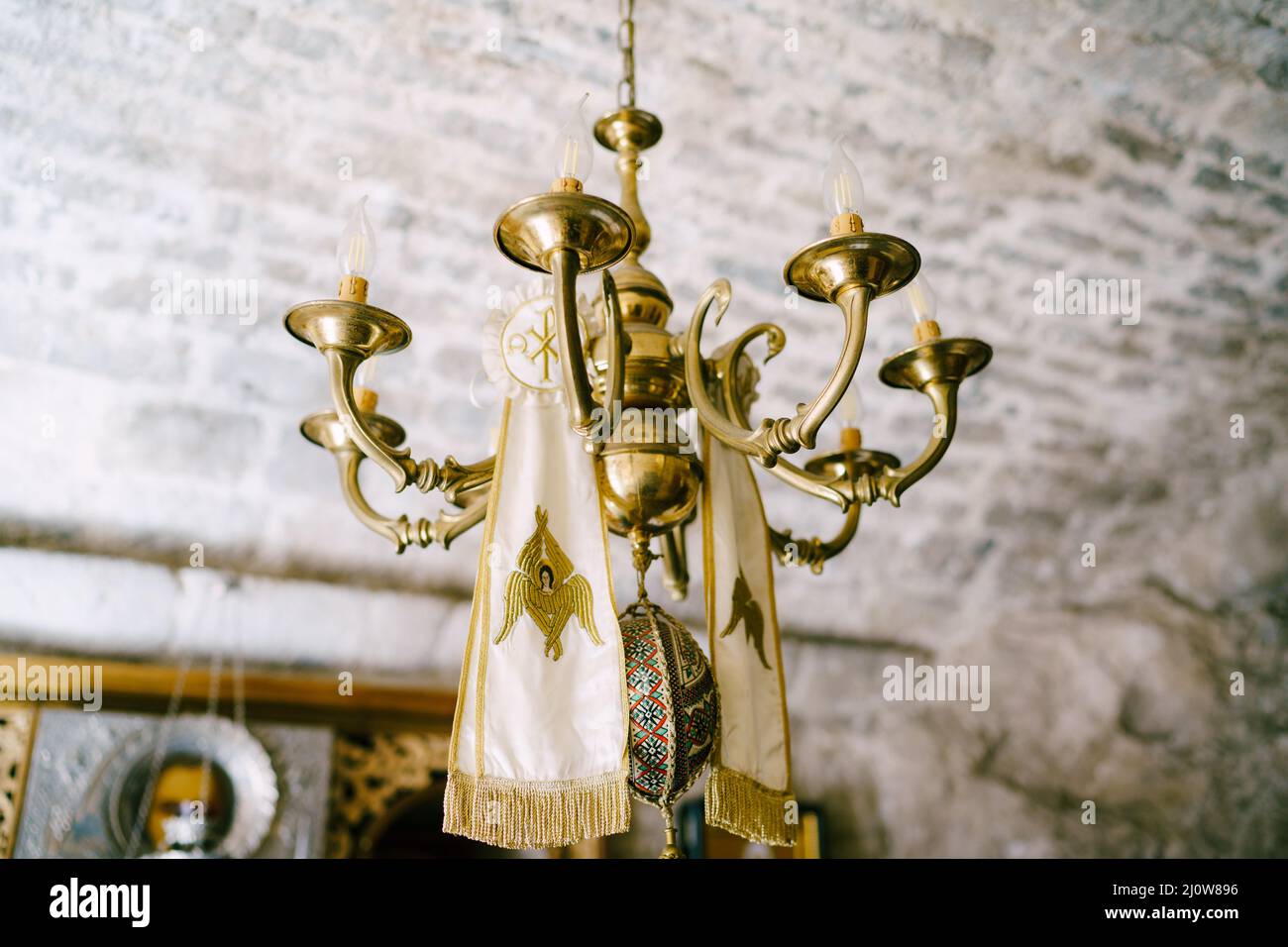 Simple chandelier on a chain in a church under a stone ceiling Stock Photo