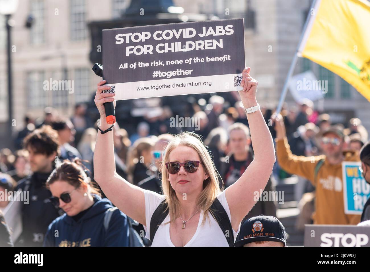 Protest taking place against vaccinating children for Covid 19, joined by anti-vaxxers. White, Caucasian female with placard Stock Photo