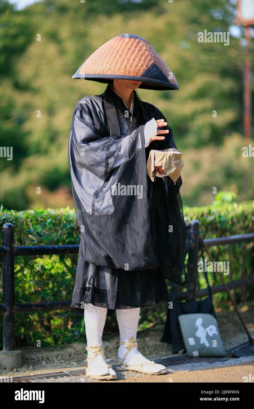 Buddhist monk chanting sutras and collecting donations in the Kyoto street. Japan Stock Photo