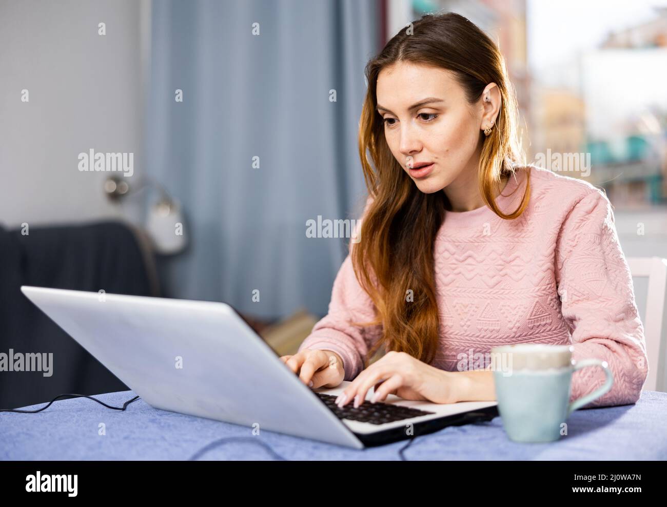 Woman communicates over internet using laptop at home Stock Photo - Alamy