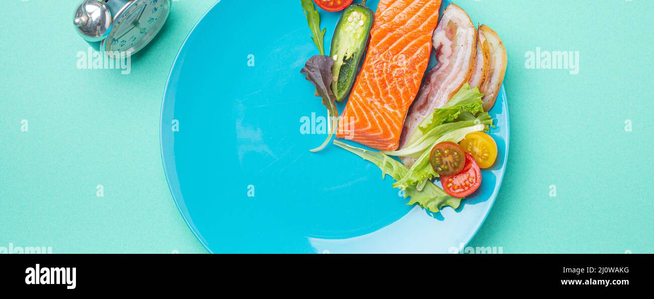 Intermittent fasting low carb hight fats diet concept flat lay, healthy food on blue plate Stock Photo