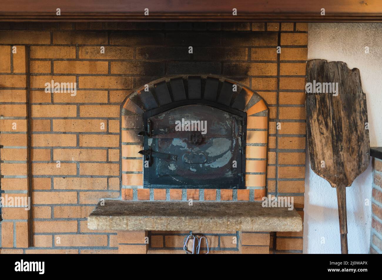 Shot of a traditional brick pizza oven with an old wooden peel in bright  light Stock Photo - Alamy