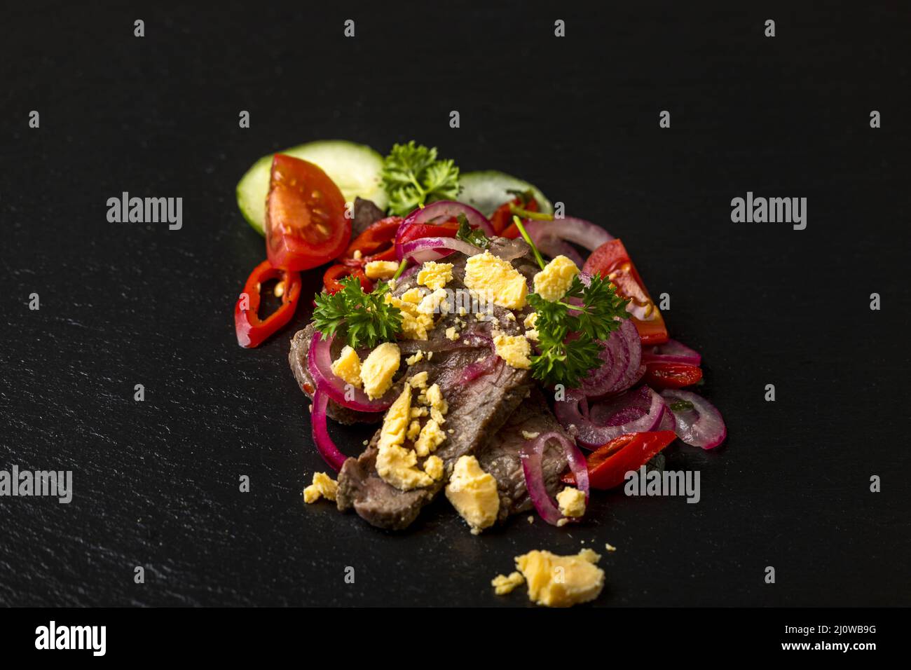 Thai meat salad on black slate Stock Photo