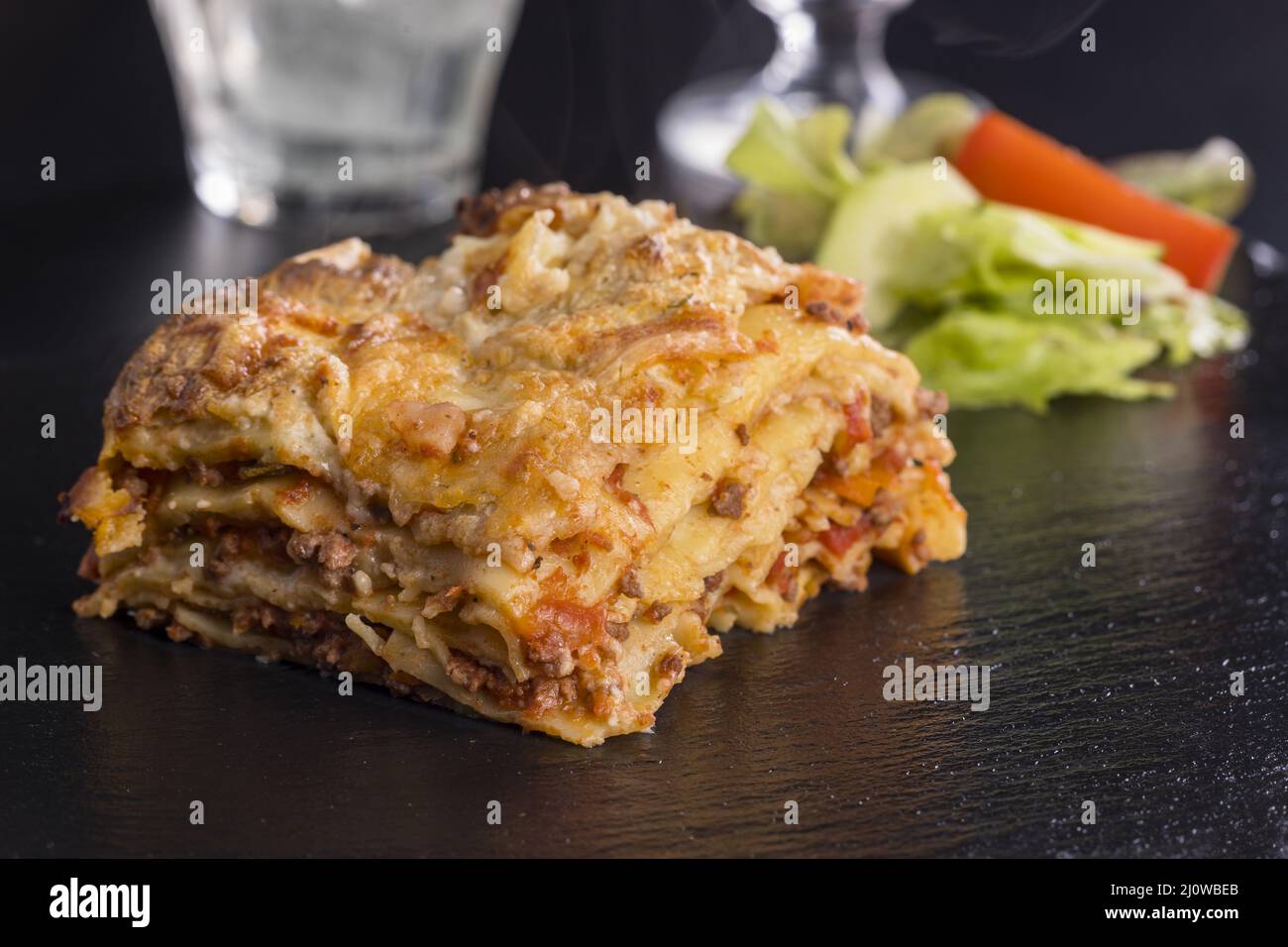Fresh lasagna on black slate Stock Photo