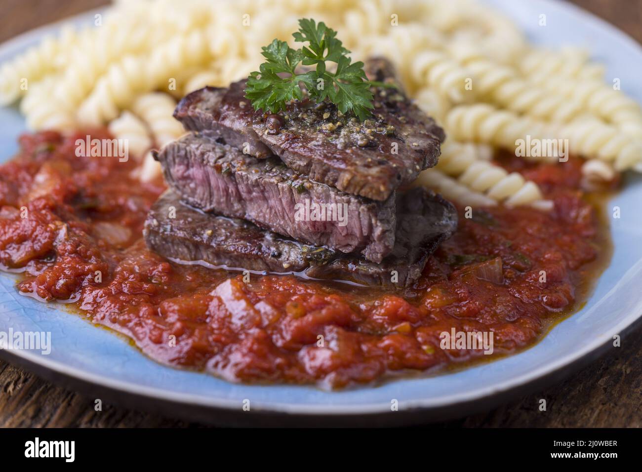 Sliced steak with spirelli pasta Stock Photo