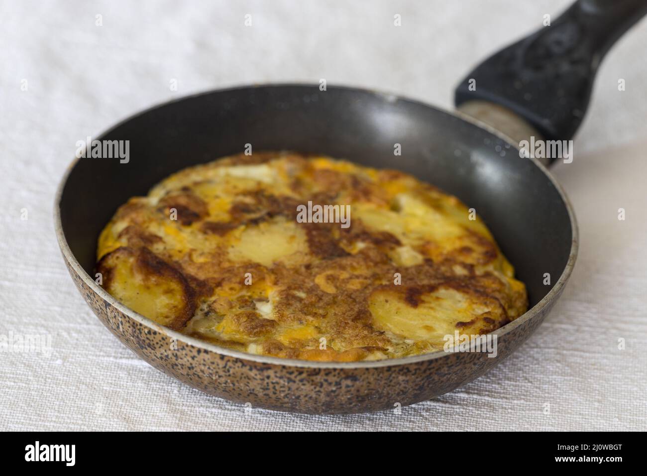 Tortilla Espanola in a pan on white Stock Photo