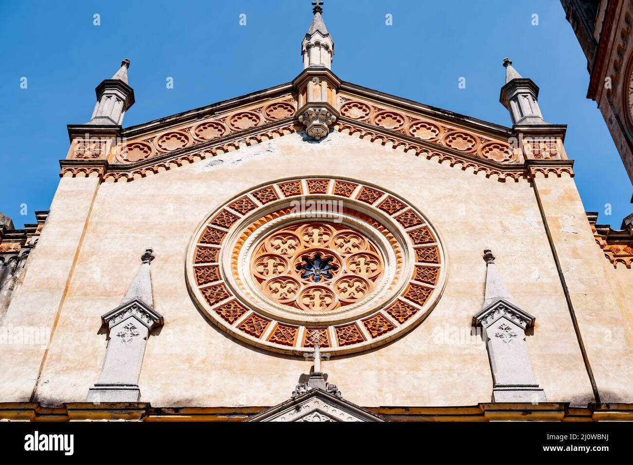 Rose window with floral patterns on the wall of an ancient church Stock Photo