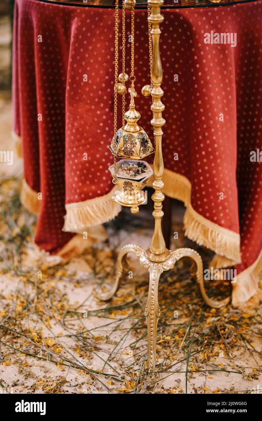 Smoking censer hangs on a gold stand in a church Stock Photo
