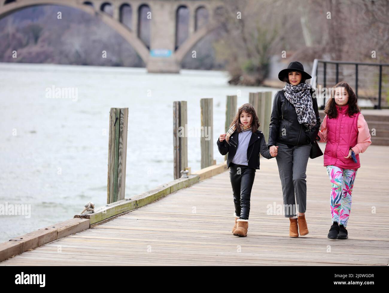Mother and two daughters walking on the boardwalk at Washington Harbor, in Georgetown, Washington DC, USA Stock Photo
