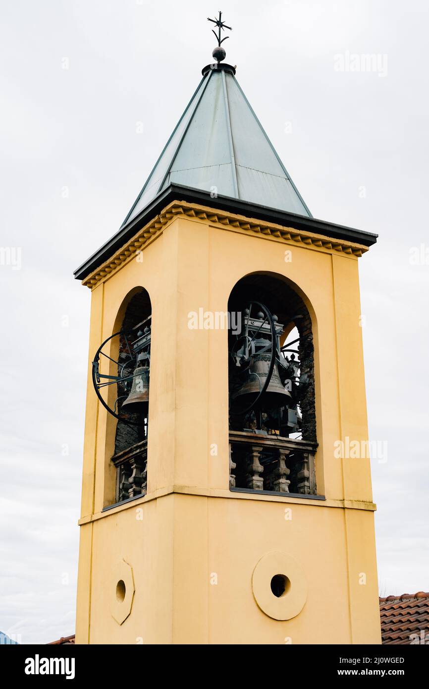 Yellow bell tower spire with vintage black bells Stock Photo