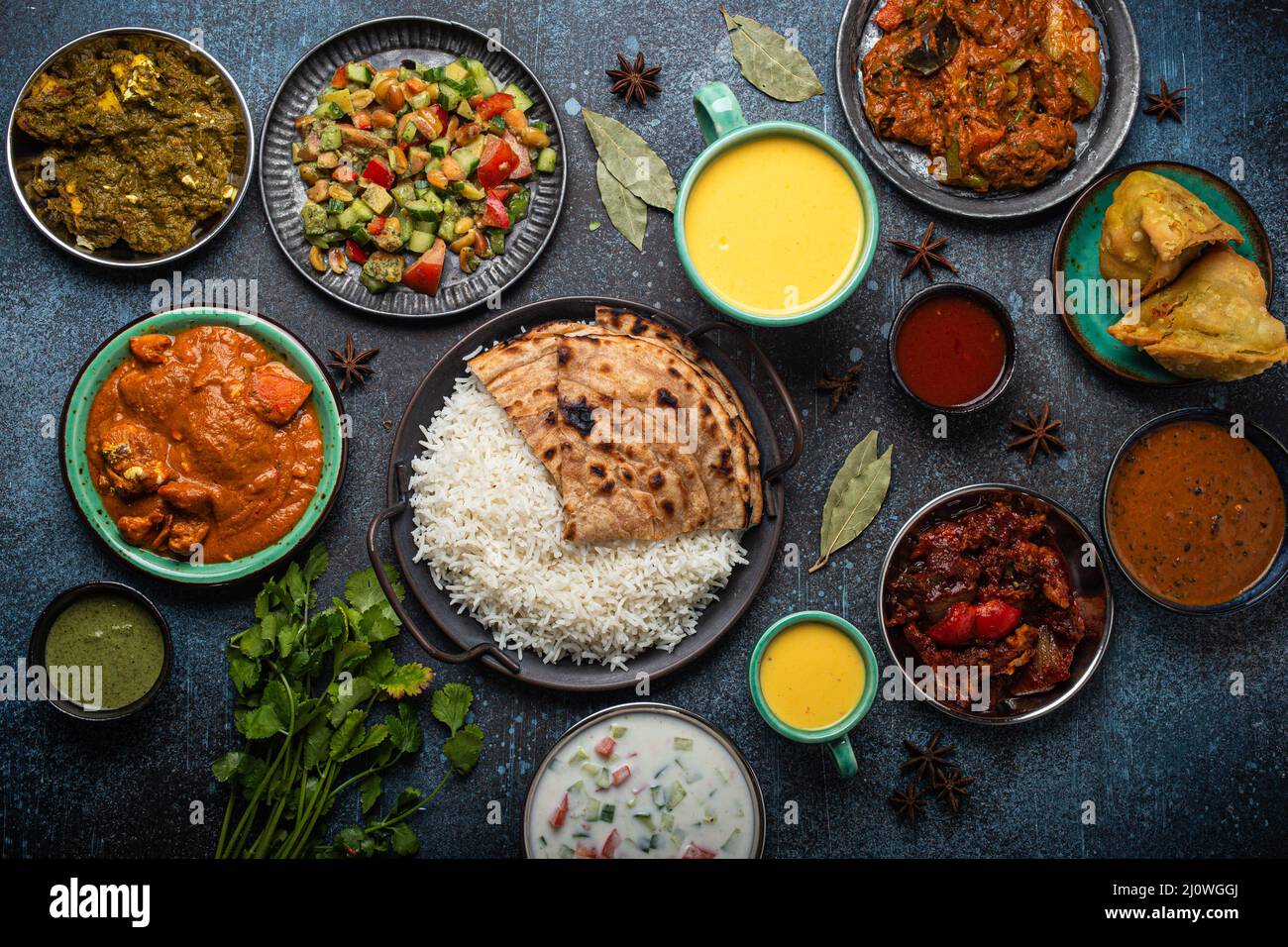 Assorted Indian ethnic food buffet on rustic concrete table from above ...