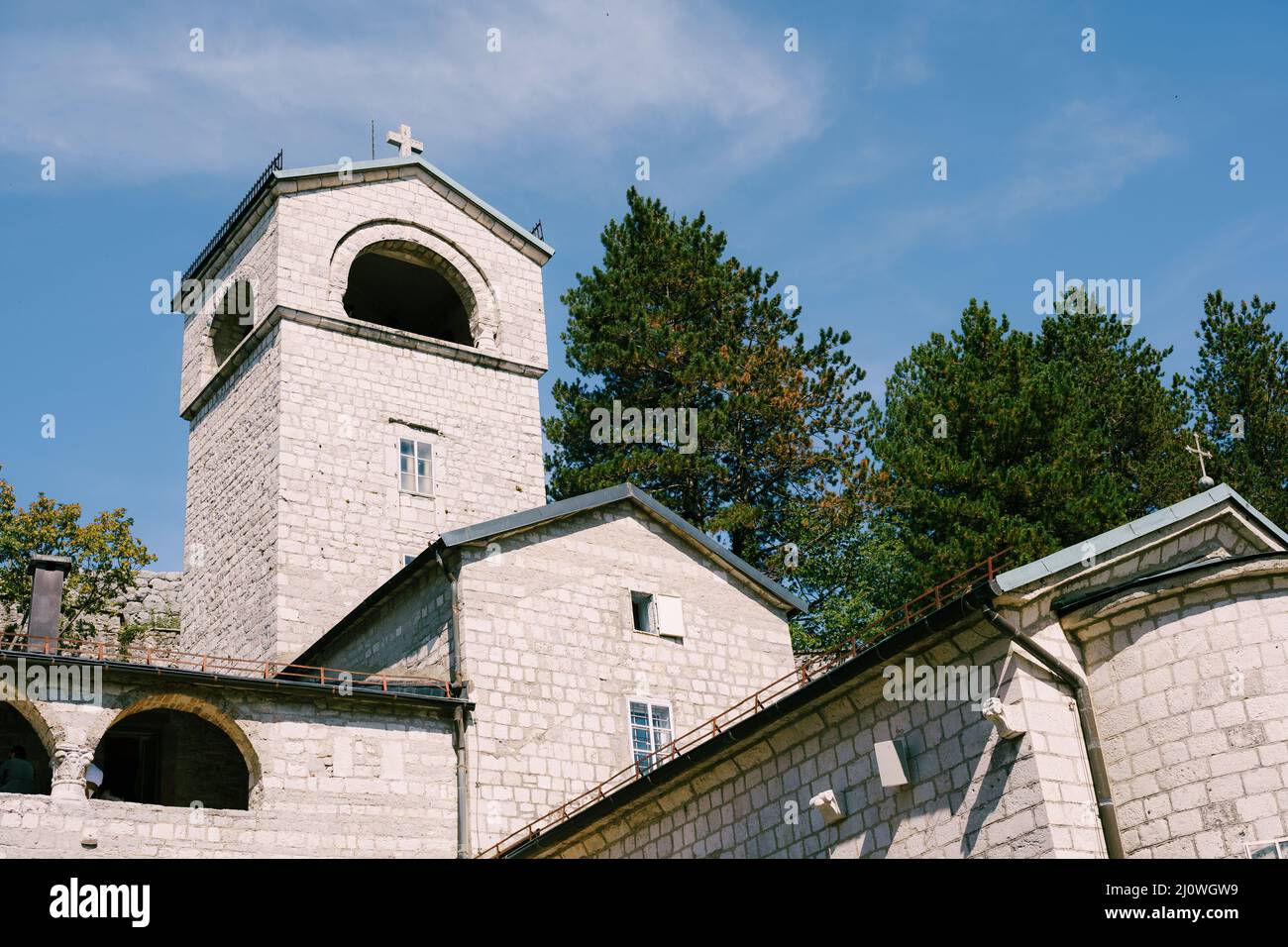 Stone monastery in Cetinje surrounded by green trees. Montenegro Stock Photo