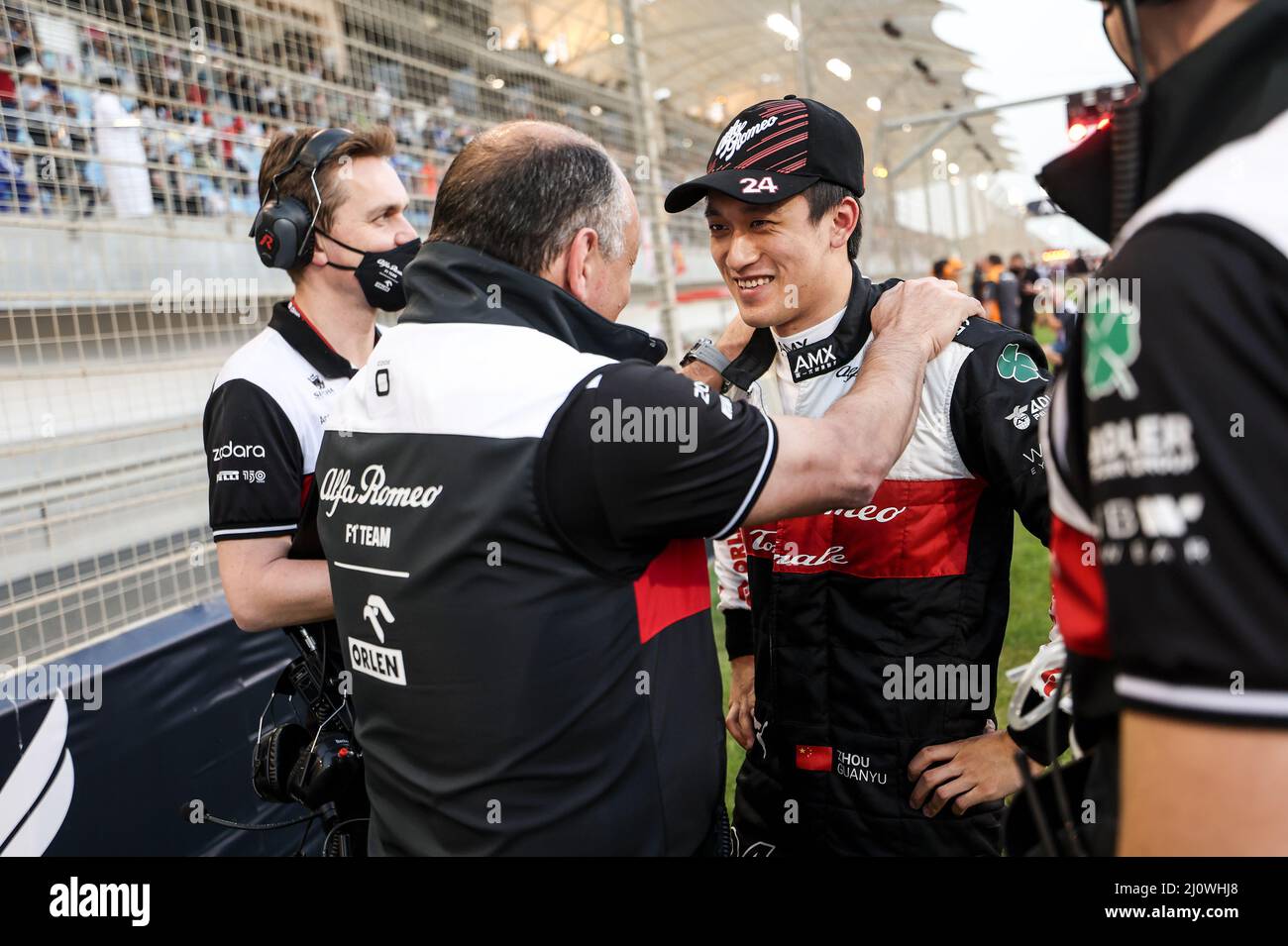 (220321) -- SAKHIR, March 21, 2022 (Xinhua) -- Alfa Romeo's Chinese driver Zhou Guanyu (R) chats with his team during the Bahrain Formula One Grand Prix at the Bahrain International Circuit in the city of Sakhir on March 20, 2022. (DPPI/Handout via Xinhua) Stock Photo
