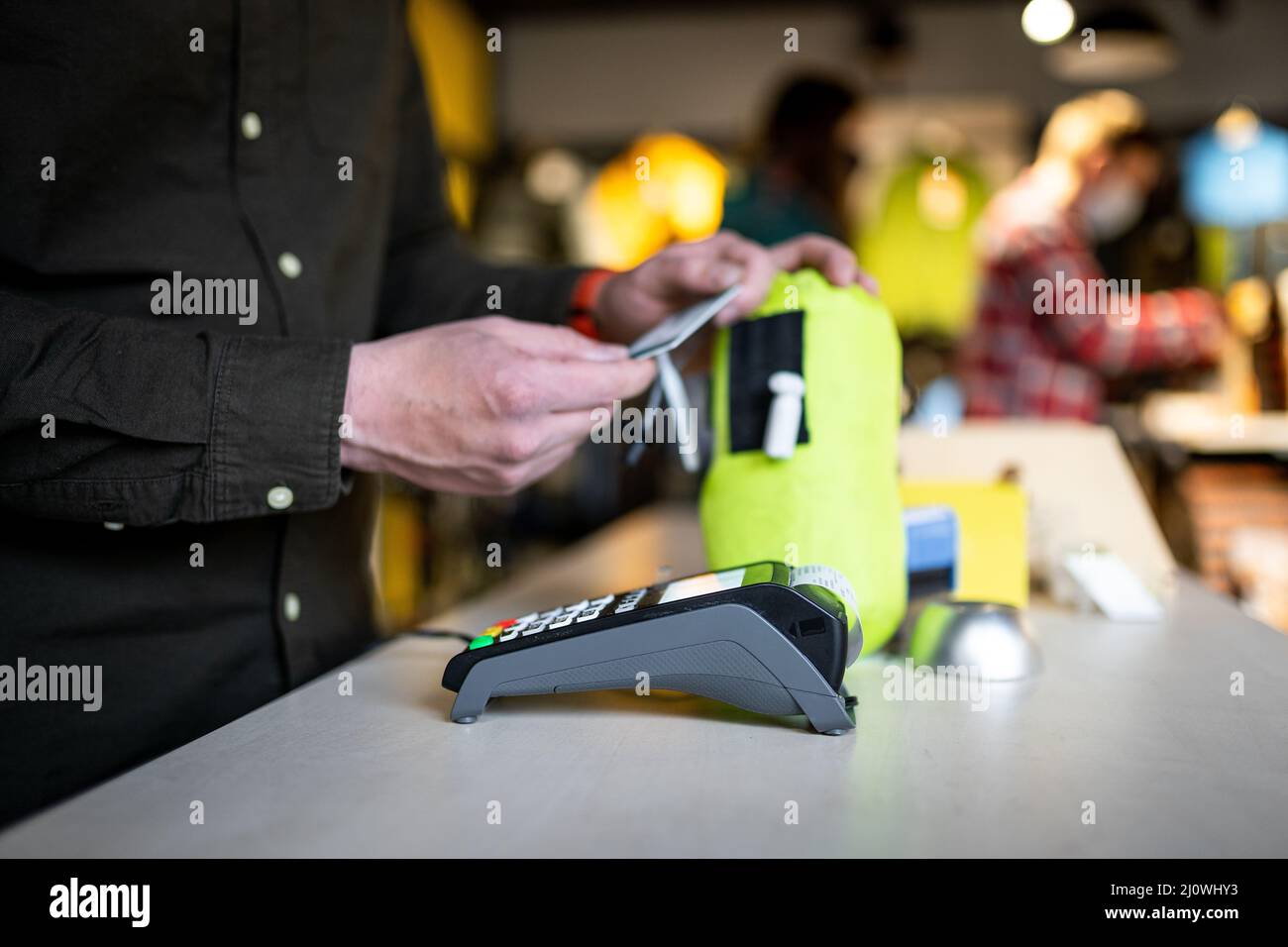 Salesman holds payment terminal while holding receipt for completing purchase. Hands close up. Concept of NFC, business and bank Stock Photo