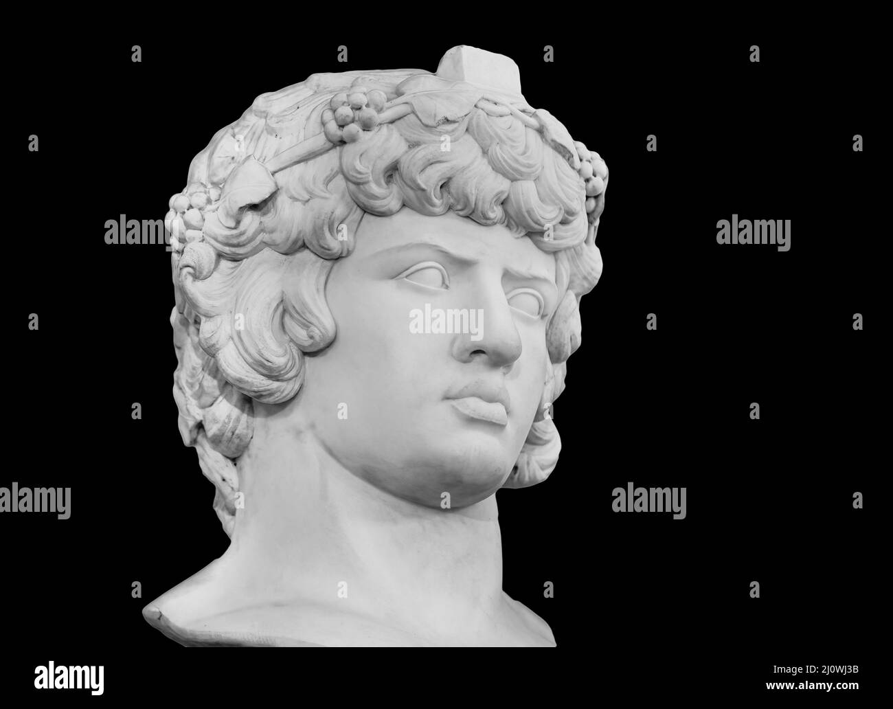 Gypsum copy of famous ancient statue Antinous head isolated on a black background. Plaster antique sculpture young man face. Ren Stock Photo
