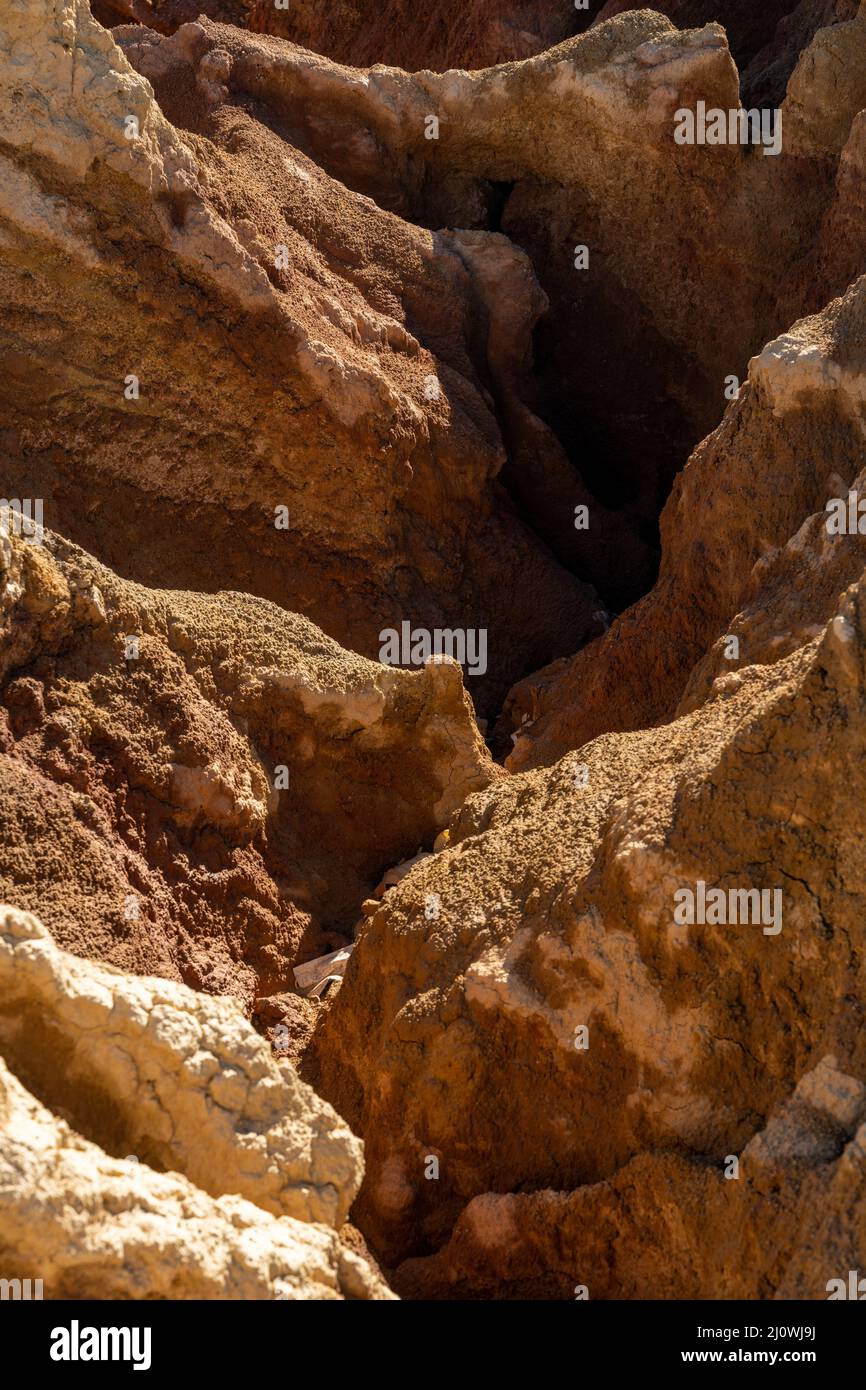 A close up of an erosion crack running through red dirt and earth in an ...