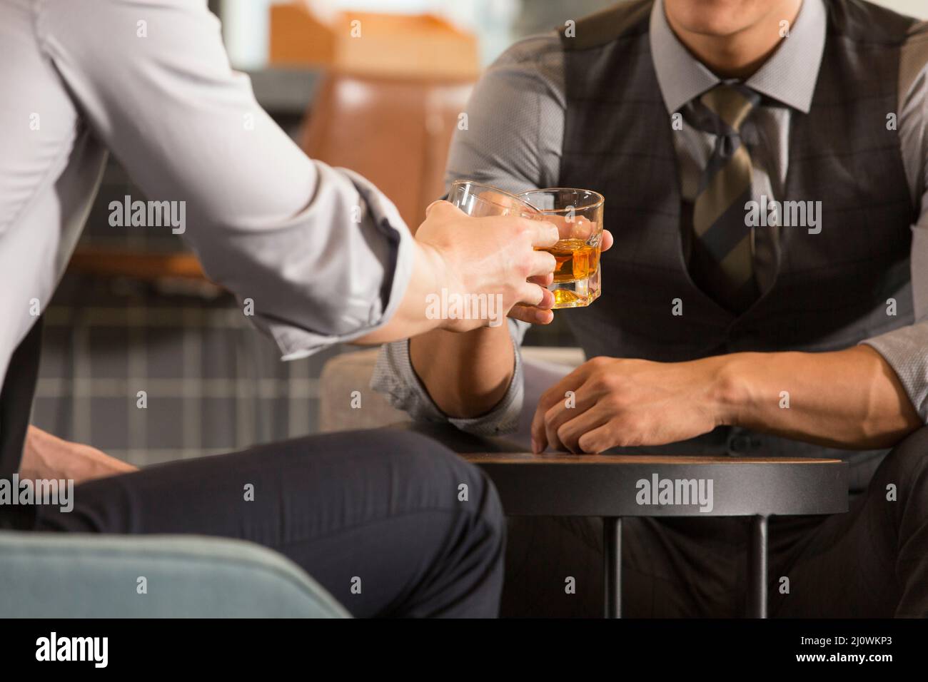 Close-up of Chinese businessmen toasting their success at a bar Stock Photo