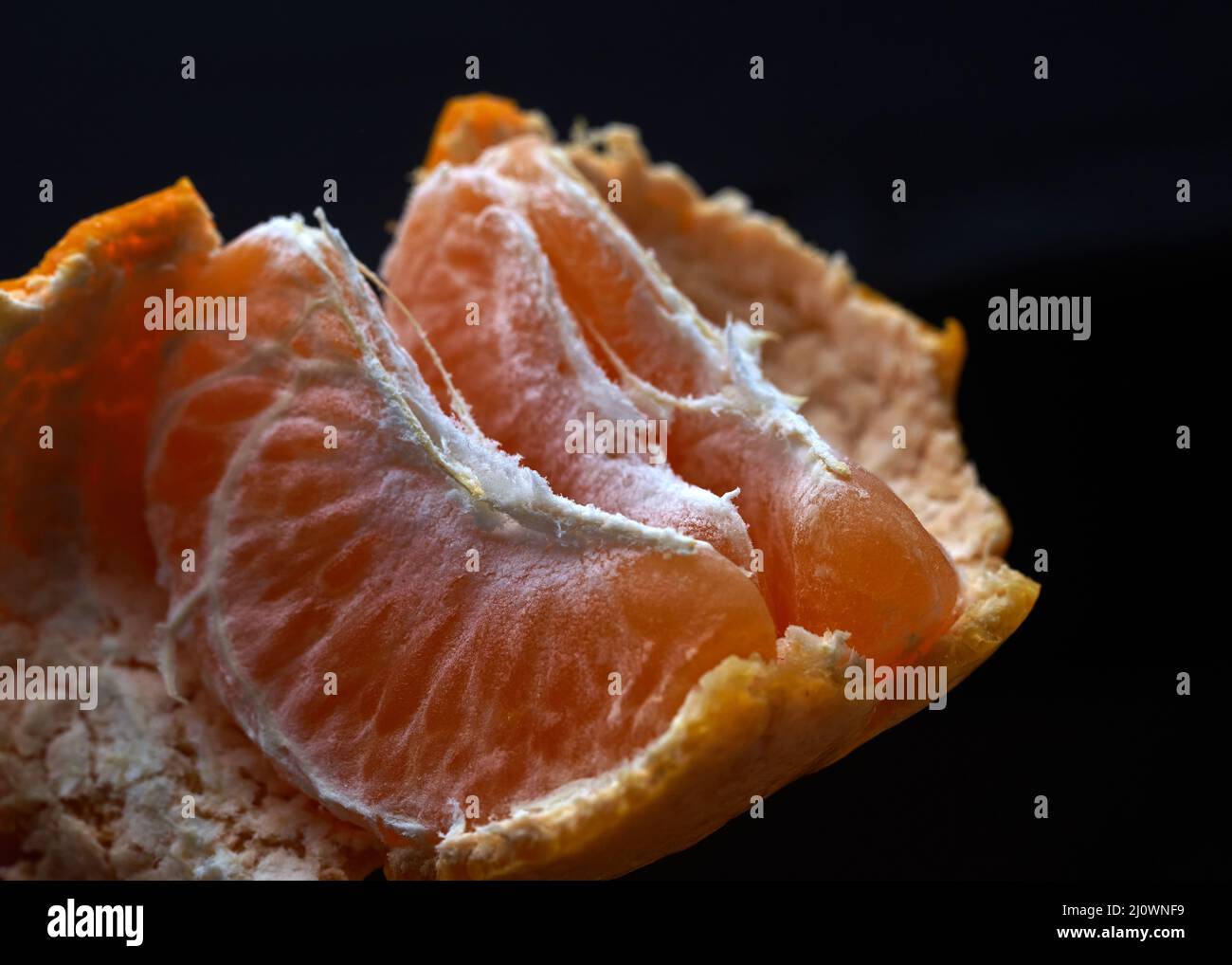 Peeled tangerine on a blue background Stock Photo