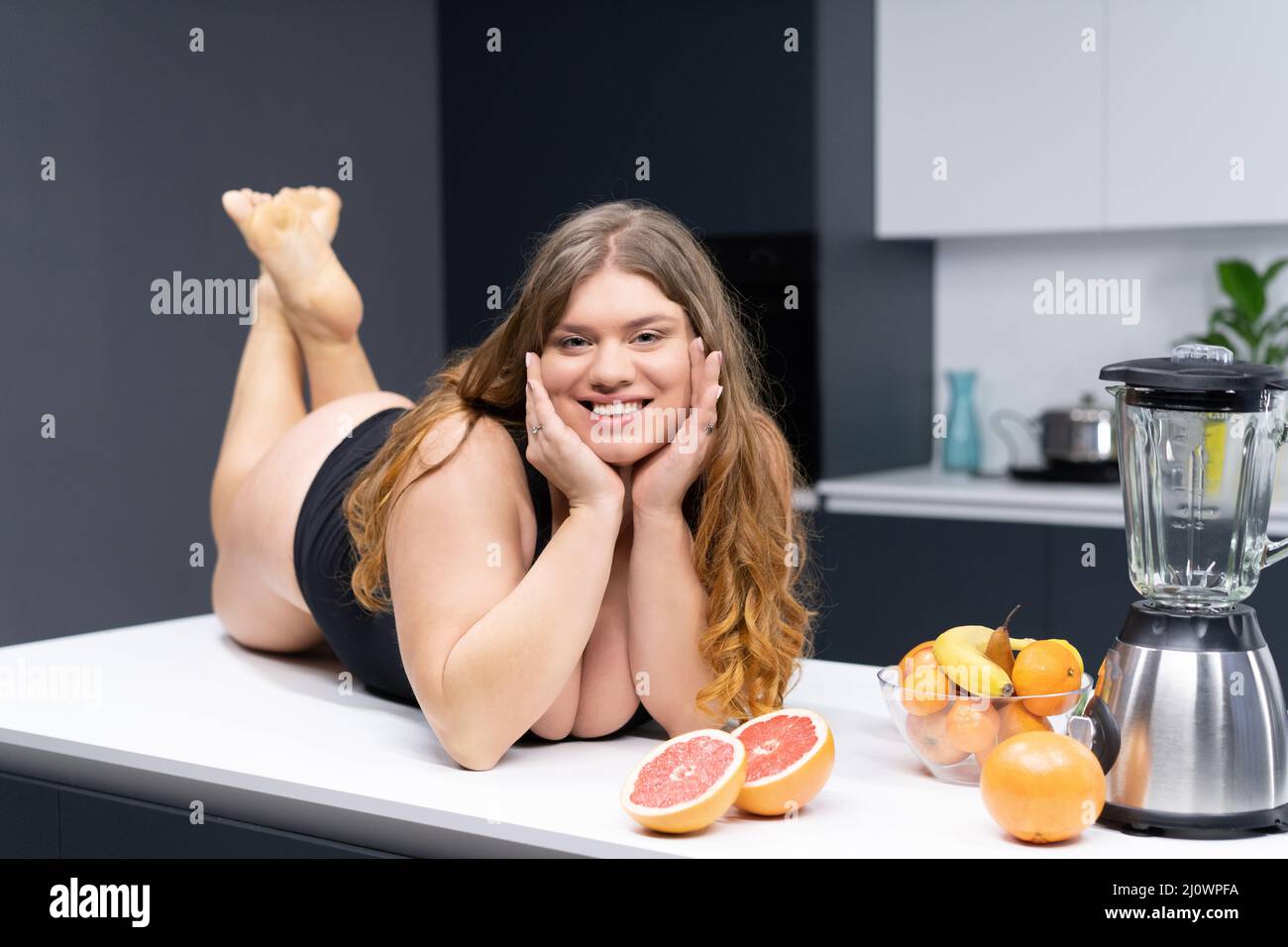 Concept weight loss, detox, body cleansing, slagging, weak immunity. Tasty vitamins in a smoothie. Young Woman smiles at camera. Stock Photo