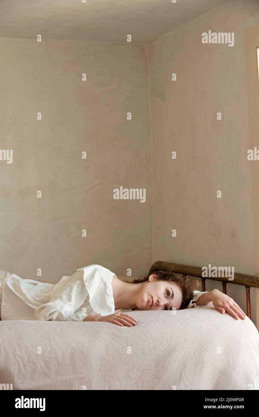 Young woman wearing white reclining in bed Stock Photo Alamy