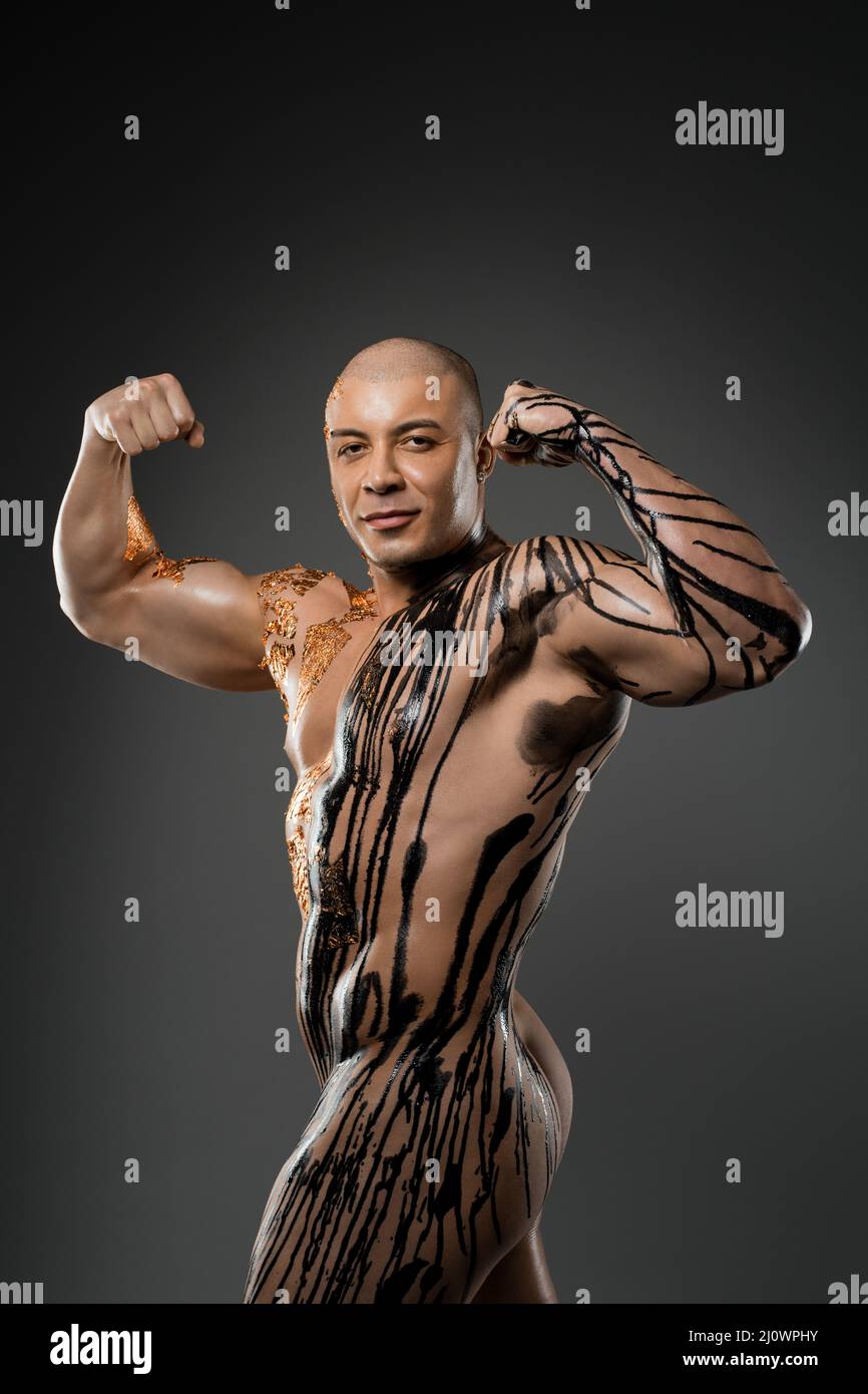 Nude man with painted body showing muscles Stock Photo