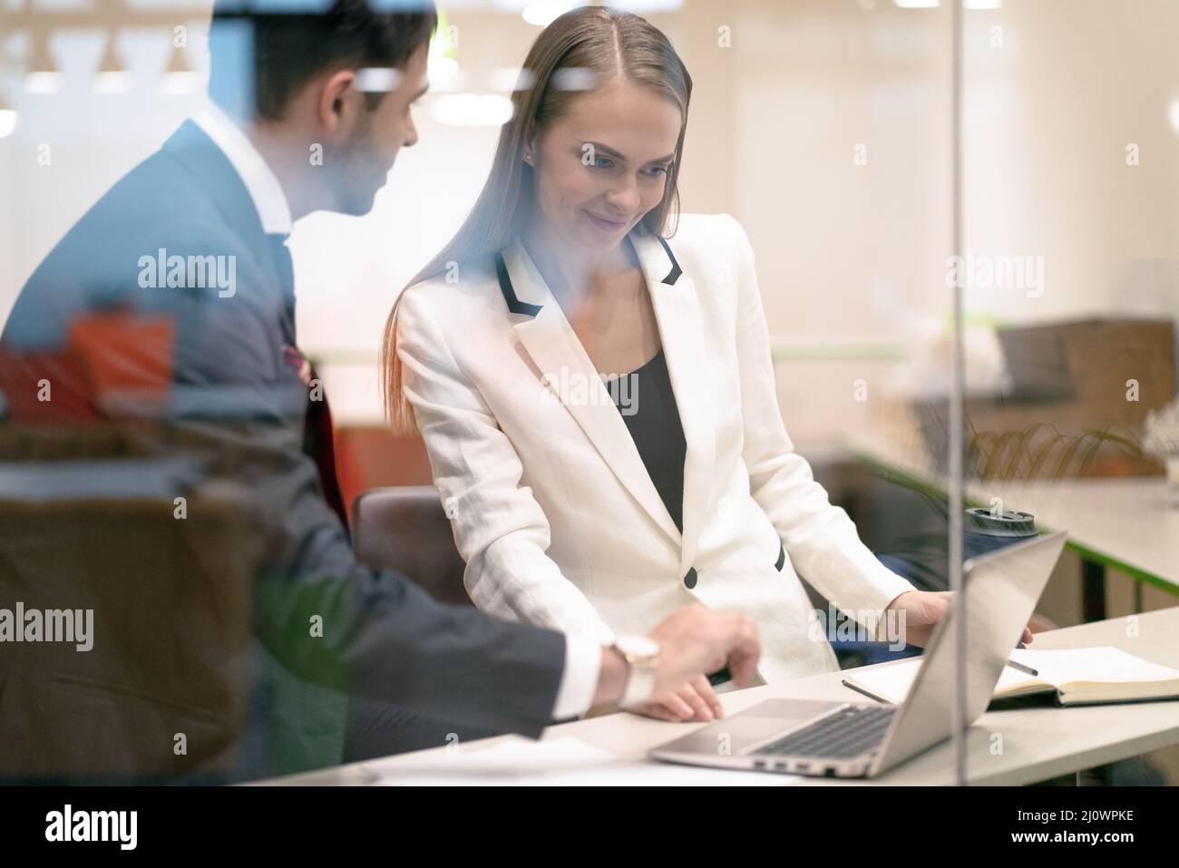 Business Couple, Man and Woman, Have a Meeting in the Office, Look at the Screen of a Laptop, Discuss New Trends in the World Ma Stock Photo