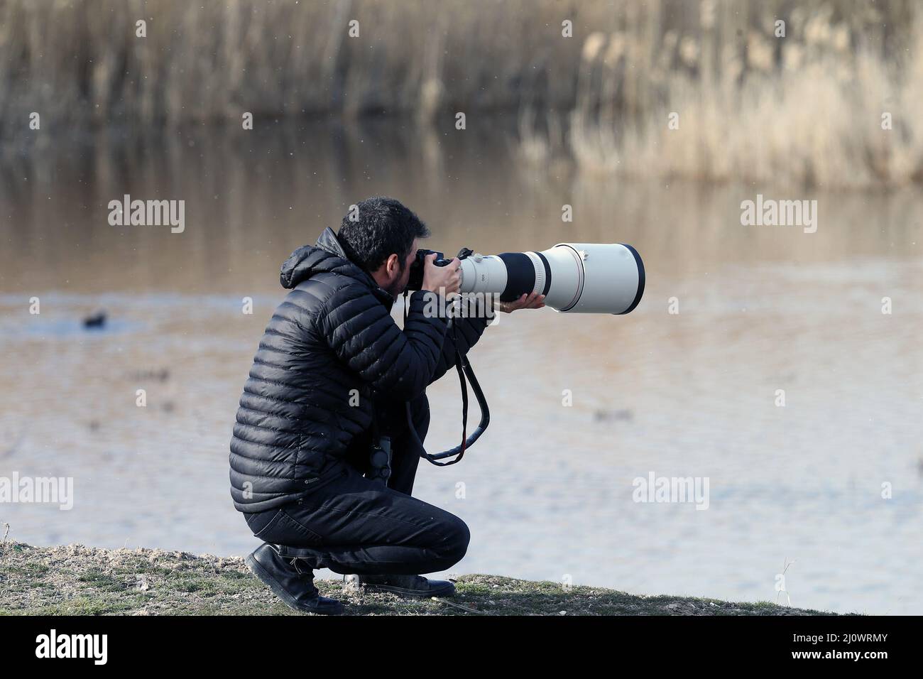 Ankara, Turkey. 18th Mar, 2022. Emin Yogurtcuoglu, a 35-year-old bird watcher, takes photos at Lake Mogan in Ankara, Turkey, on March 18, 2022. Emin Yogurtcuoglu, a Turkish self-proclaimed 'bird detective,' is constantly seeking new bird species around the world, and he wants to make his next trip to China, land of many species and home to abundant wildlife. TO GO WITH 'Feature: Turkish bird watcher eager to visit China, land of wildlife protection' Credit: Mustafa Kaya/Xinhua/Alamy Live News Stock Photo