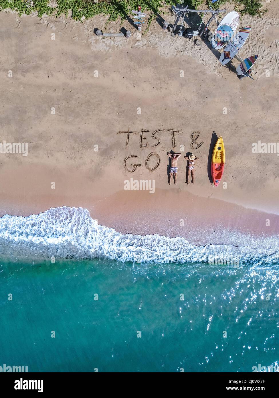 Couple on the beach with Test Go sign on the beach in Thailand Pattaya, Test and Go sign on theb beach from above with drone Stock Photo