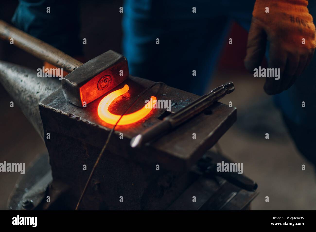 Forgar Blacksmith forges and makes metal detail with hammer and anvil at forge ...