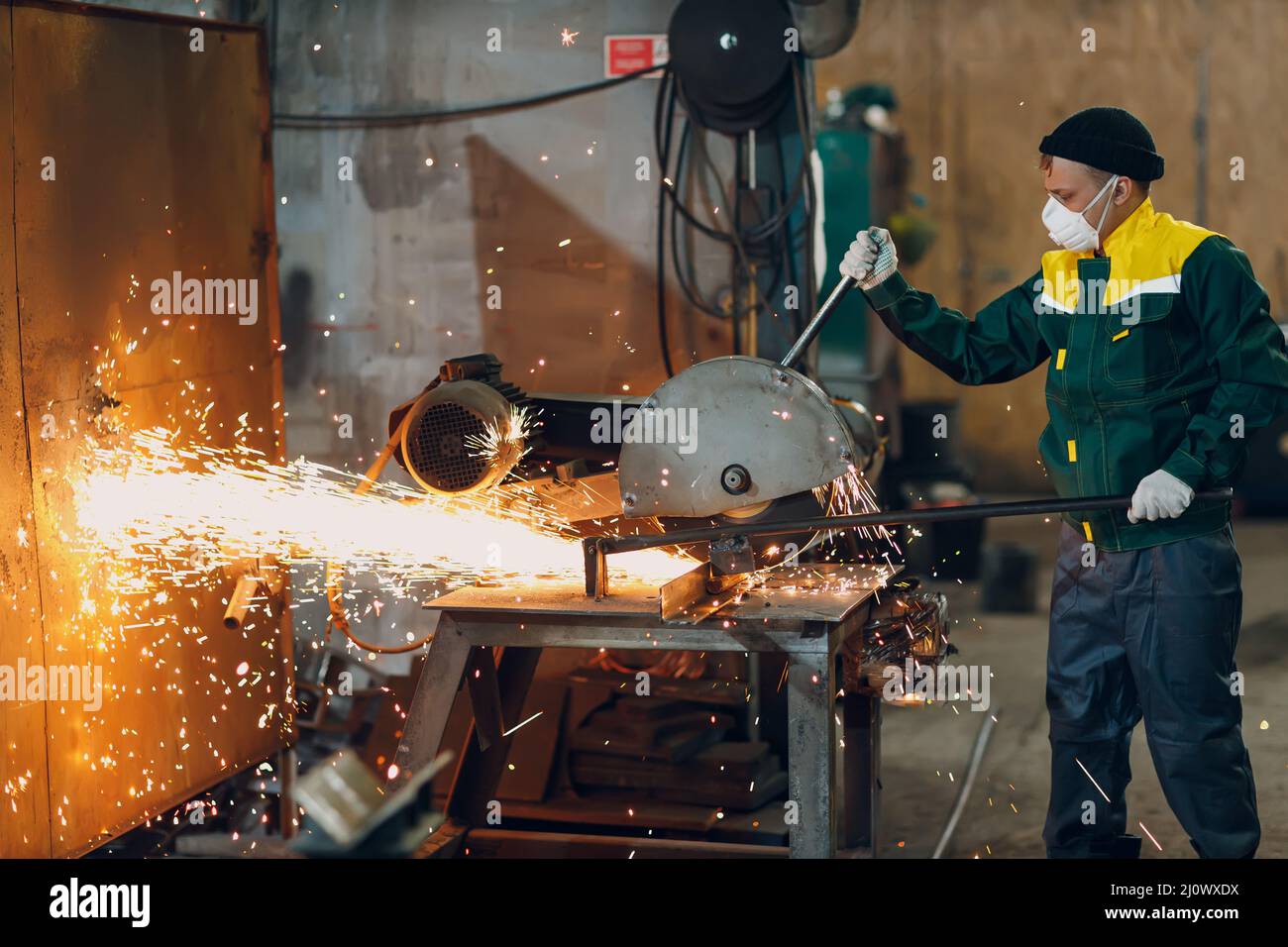 Metal processing with big angle grinder disk saw. Sparks in metalworking at factory. Stock Photo
