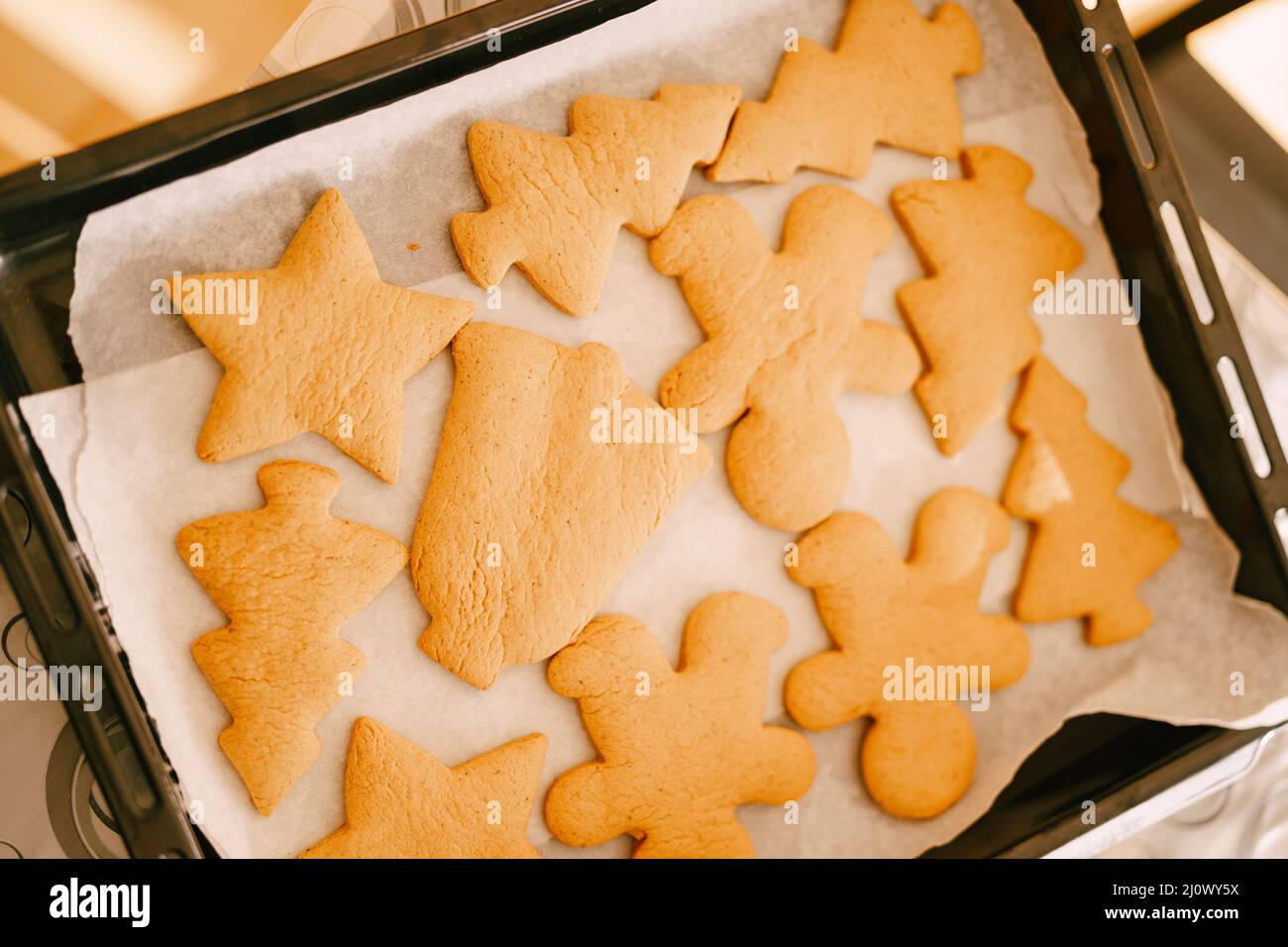 Freshly cooked gingerbread on a baking sheet from the oven, close-up of various shapes of cookies. Stock Photo